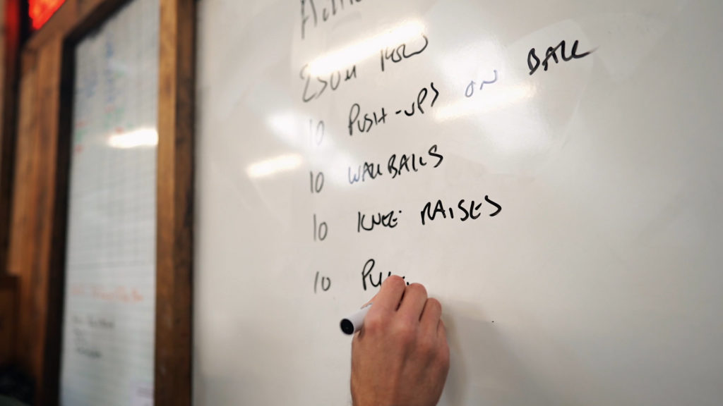 Motocross fitness workout being written on a whiteboard. 